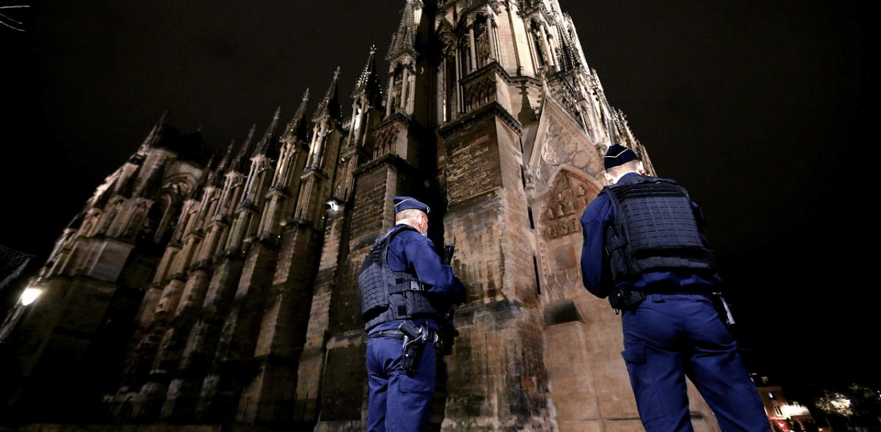 Police stand guard outside the the Notre-Dame de Reims cathedral in Reims, eastern France, on October 30, 2020, ahead of a "mass for France" in homage to the three victims of a knife attack at a church in Nice the previous day. Credit: AFP Photo
