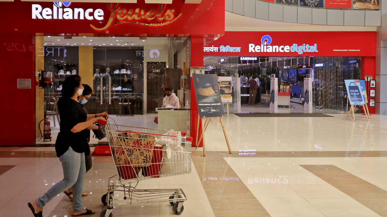 Customers walk past stores of Reliance Industries Ltd, in Mumbai. Credits: Reuters Photo