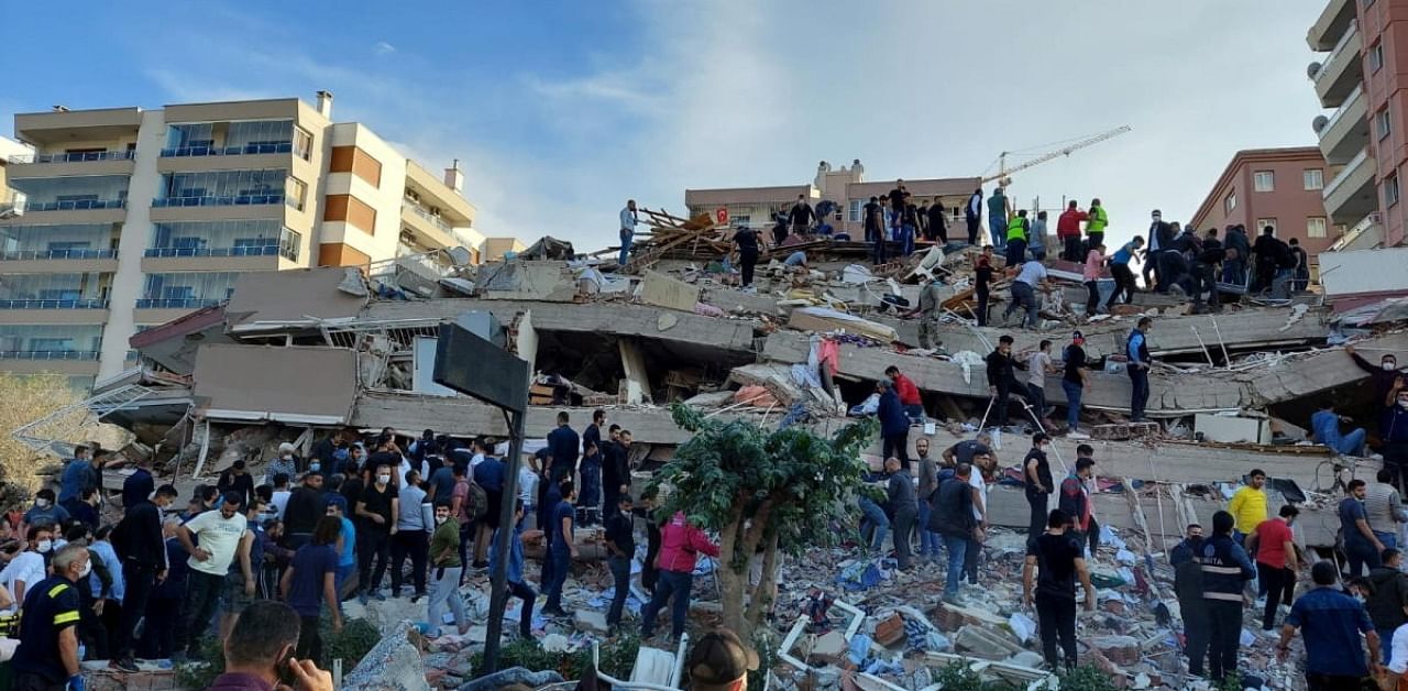 Locals and officials search for survivors at a collapsed building after a strong earthquake struck the Aegean Sea on Friday and was felt in both Greece and Turkey, where some buildings collapsed in the coastal province of Izmir, Turkey. Credit: Reuters