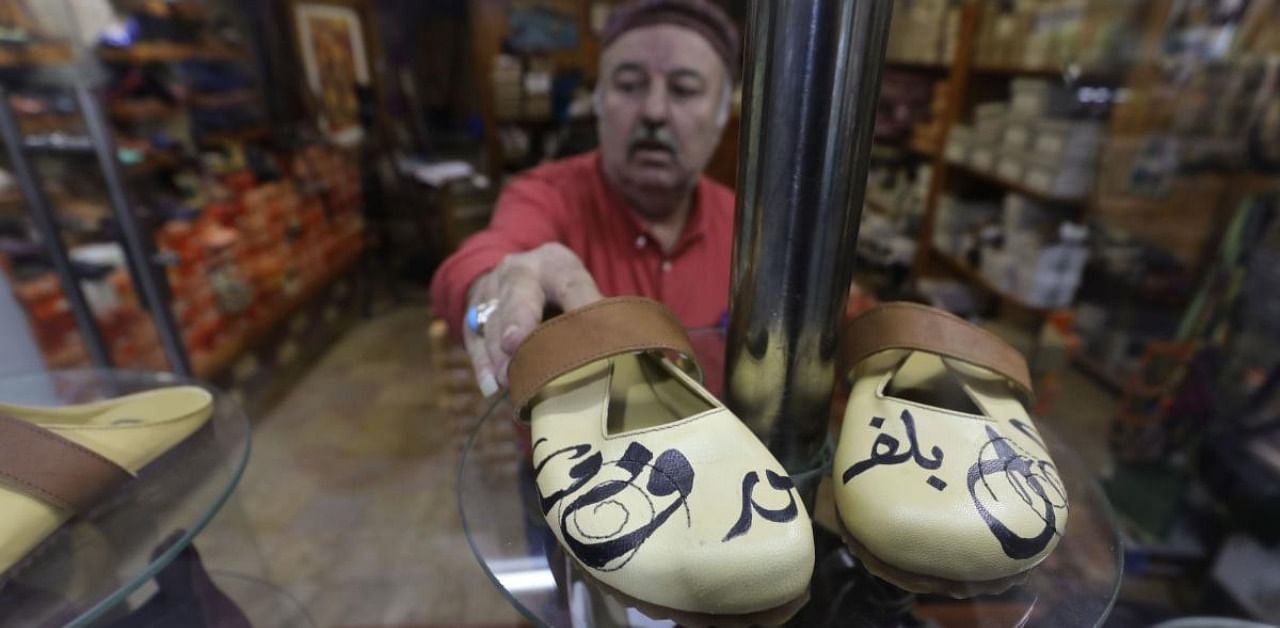A pair of women's handcrafted shoes stamped with the name of the French President in Arabic calligraphy. Credit: AFP Photo