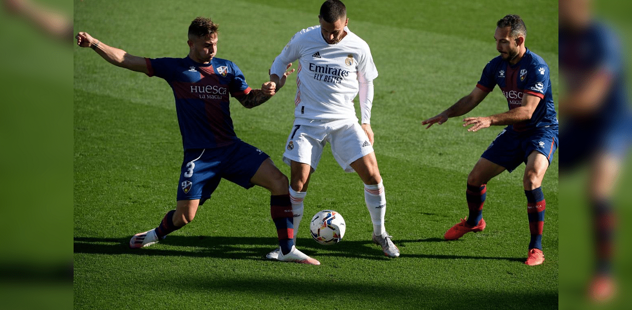 Real Madrid's Belgian forward Eden Hazard (C) challenges Huesca's Spanish defender Pablo Maffeo (L) and Huesca's Spanish midfielder David Ferreiro during the Spanish League football match between Real Madrid and SD Huesca at the Alfredo Di Stefano stadium in Valdebebas, northeastern Madrid, on October 31, 2020. Credit: AFP Photo