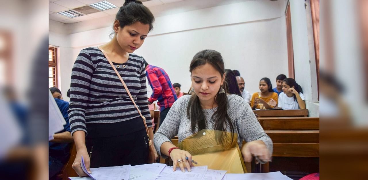 Students filling the application forms at North Campus after the first cut-off list for admissions to the colleges, under Delhi University. Credit: PTI