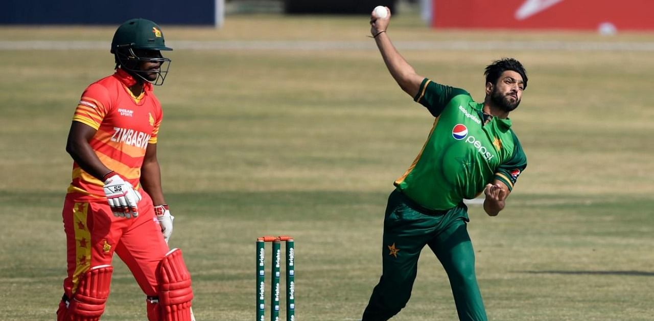 Pakistn's Haris Rauf (R) delivers the ball as Zimbabwe's captain Chamu Chibhabha (L) looks on. Credit: AFP Photo