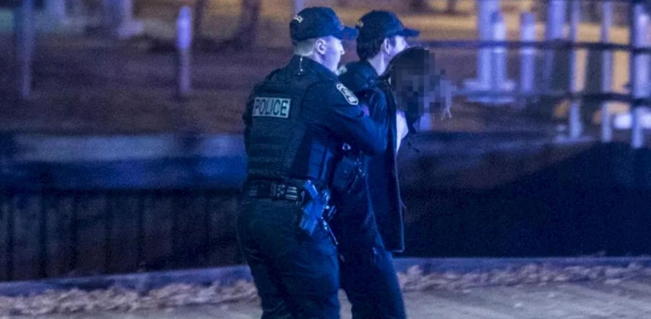 Police officers detain a man near the National Assembly of Quebec, in Quebec City, early on November 1, 2020, after two people were killed and five wounded by a sword-wielding suspect dressed in medieval clothing. Credit: AFP