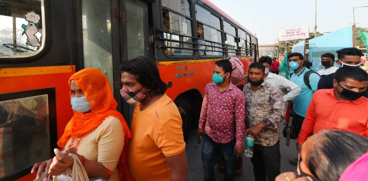 Passengers wait to board a DTC bus, in New Delhi. Credit: PTI