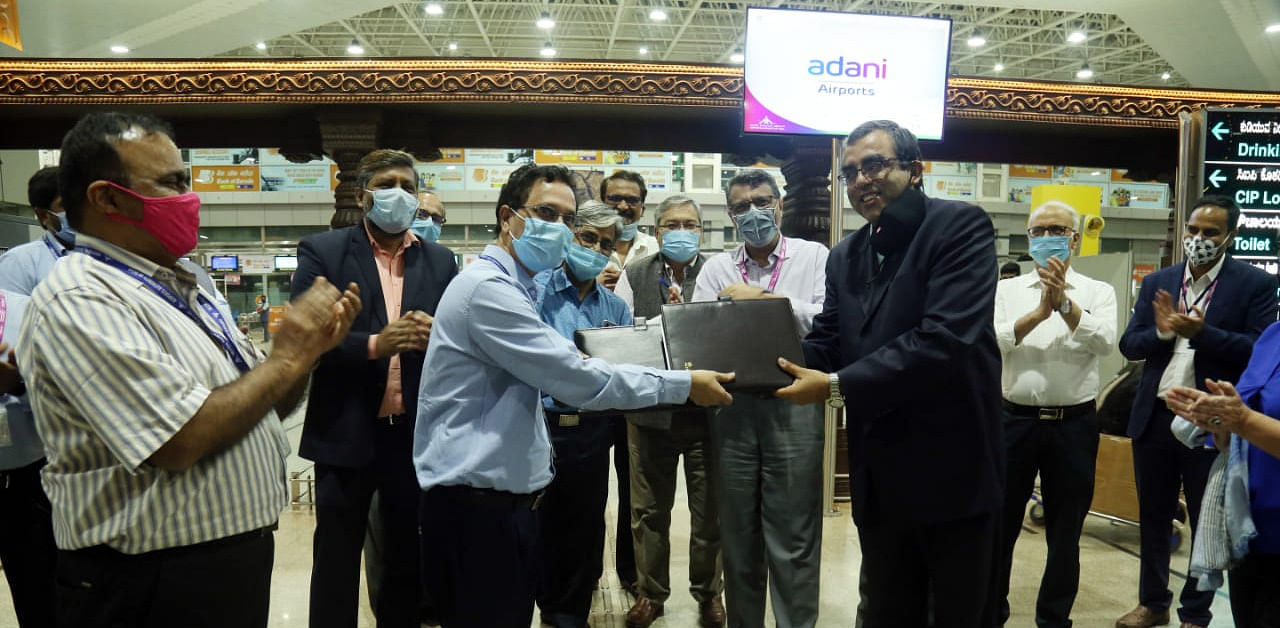 A team of AAI officials led by Mangalore International Airport (MIA) Director V V Rao seen symbolically handing over documents and key to Adani Mangaluru International Airport Limited Chief Executive Officer (CEO) Ashutosh Chandra and Adani Airports Chief Executive Officer Behnad Zandi at the Airport in Kenjar. Credit: DH