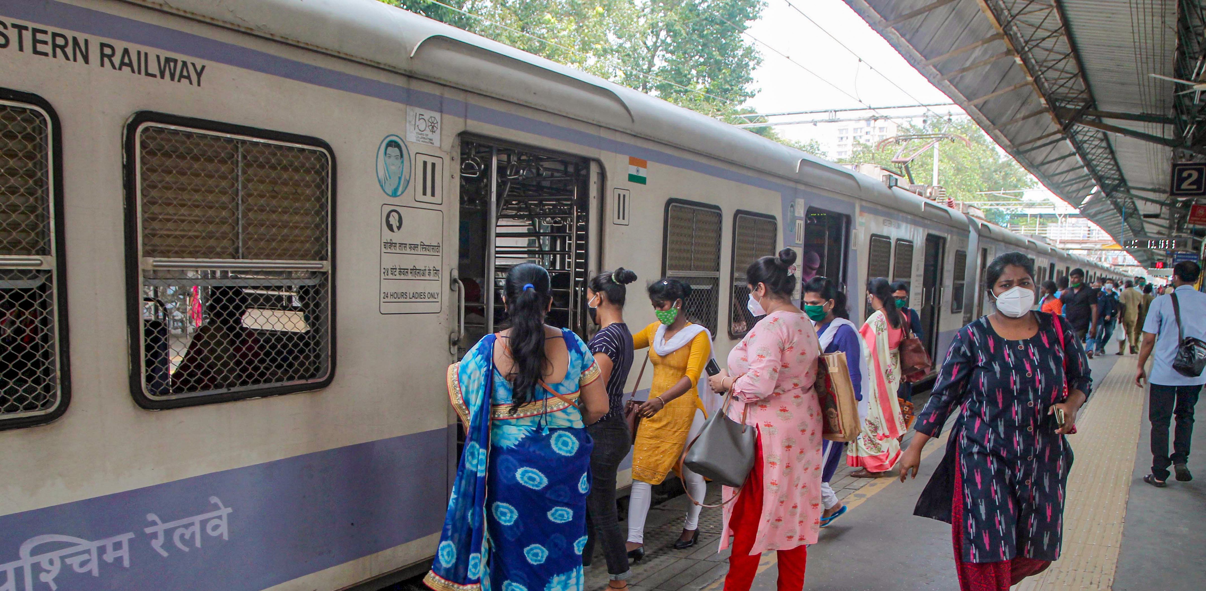 Women passengers board a local train after the authorities allowed them to commute during non-peak hours from 11 AM to 3 PM and from 7 PM till the end of the service, at CSMT in Mumbai. Credit: PTI