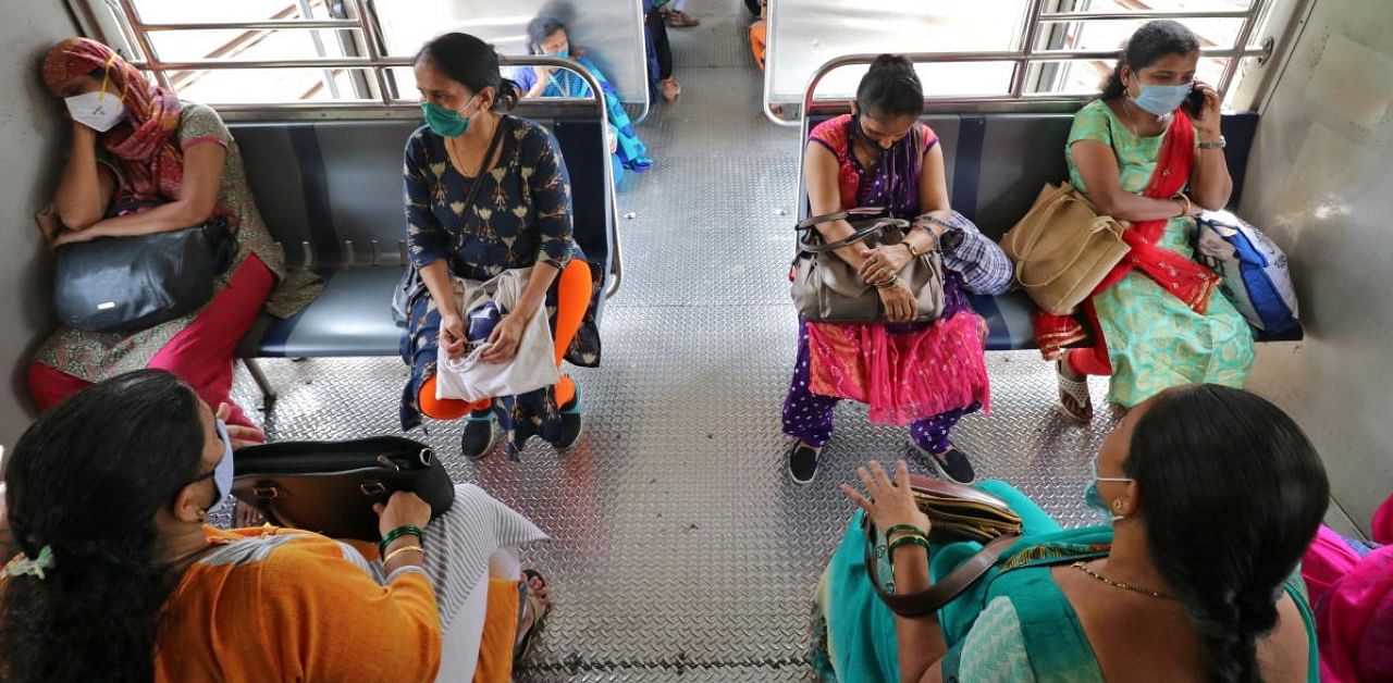 Women wearing protective face masks commute in a suburban train in Mumbai. Credit: Reuters.