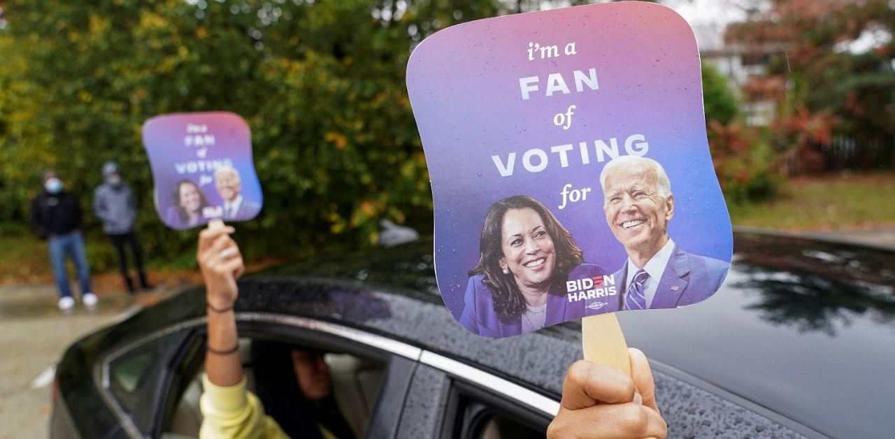 People hold fans with the images of US Democratic presidential candidate Joe Biden and vice presidential nominee Kamala Harris before a campaign event in Philadelphia, Pennsylvania. Credit: Reuters Photo