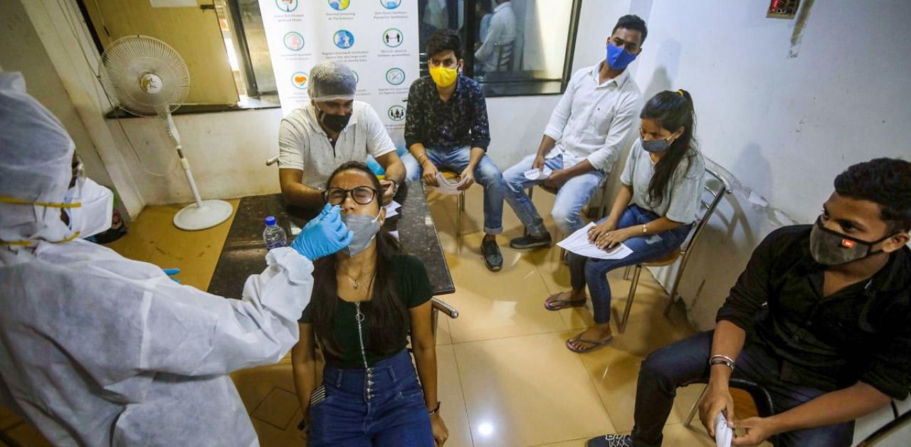 Health workers collect swab samples of people for the Covid-19 test at Malad. Credit: PTI.