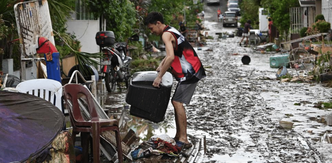 Residents clean their homes following flooding in Batangas City, south of Manila on November 2, 2020, after super Typhoon Goni made landfall in the Philippines on November 1. Credit: AFP Photo
