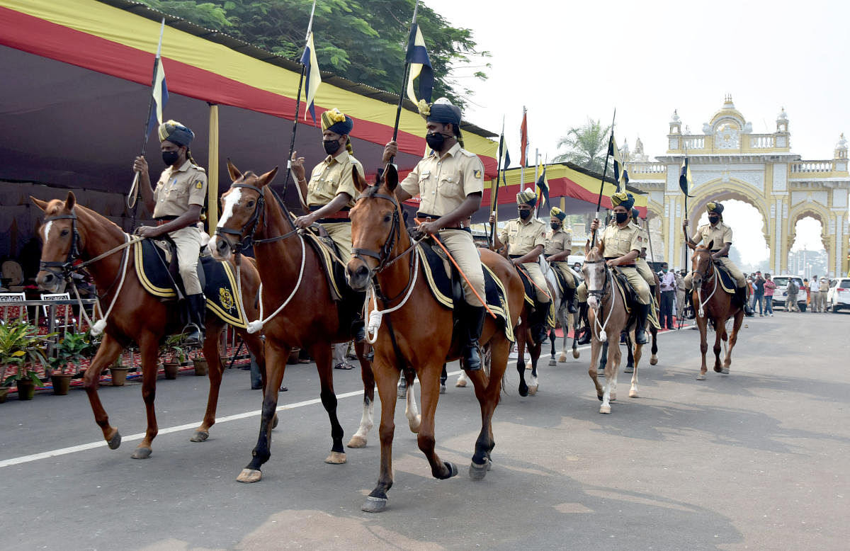Mounted police participate on the march as part of Kannada Rajyotsava celebration organised in front of Kote Anjaneya Swami temple near Mysuru Palace, on Sunday.