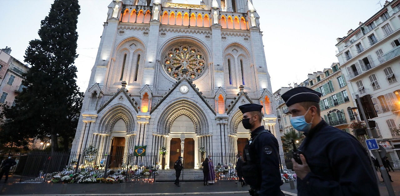 Police officers walk in front of the Notre Dame church before a mass to pay tribute to the victims of a deadly knife attack in Nice. Credit: Reuters Photo