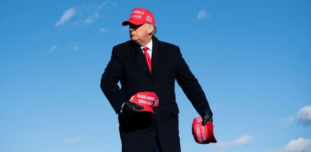 US President Donald Trump throws hats to supporters during a Make America Great Again rally at Wilkes-Barre Scranton International Airport November 2, 2020, in Avoca, Pennsylvania. Credit: AFP.