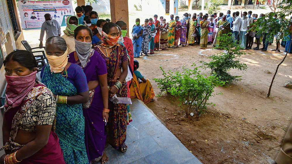 Voters stand in a long queue to cast their votes for Dubbaka by-election, in Hyderabad. Credits: PTI Photo