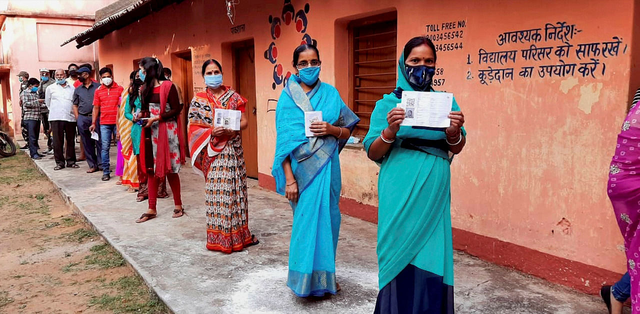 Women show their fingers marked with indelible ink after casting vote during the Jharkhand Assembly bypolls, amid the ongoing coronavirus pandemic, in Dumka district. Credit: PTI Photo