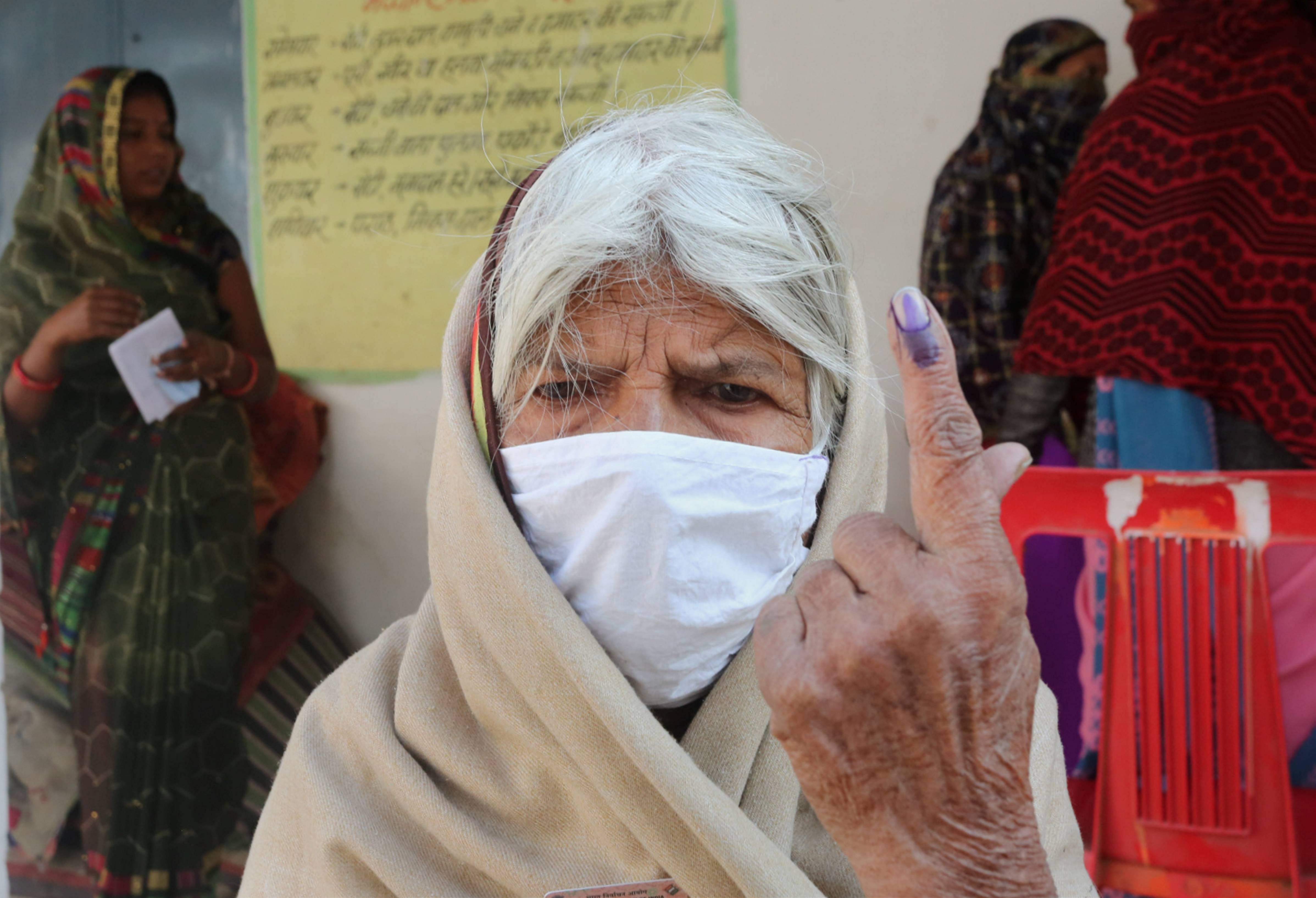 n elderly woman shows her finger marked with indelible ink after casting vote during the Madhya Pradesh Assembly bypolls, amid the ongoing coronavirus pandemic, in Raisen district, Tuesday, Nov. 3, 2020. Credit: PTI Photo