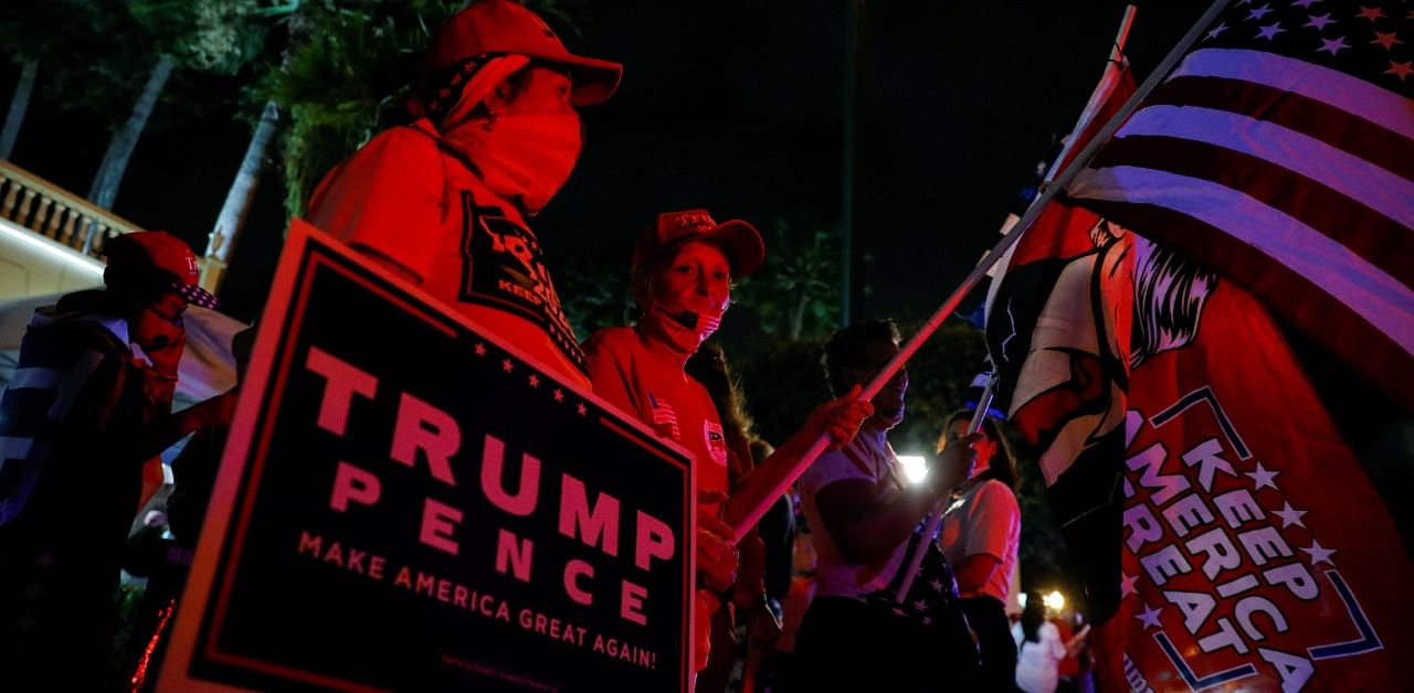 Supporters of US President Donald Trump hold signs and flags outside Versailles Restaurant at Little Havana neighbourhood in Miami, Florida, US, November 3, 2020. Credit: Reuters Photo