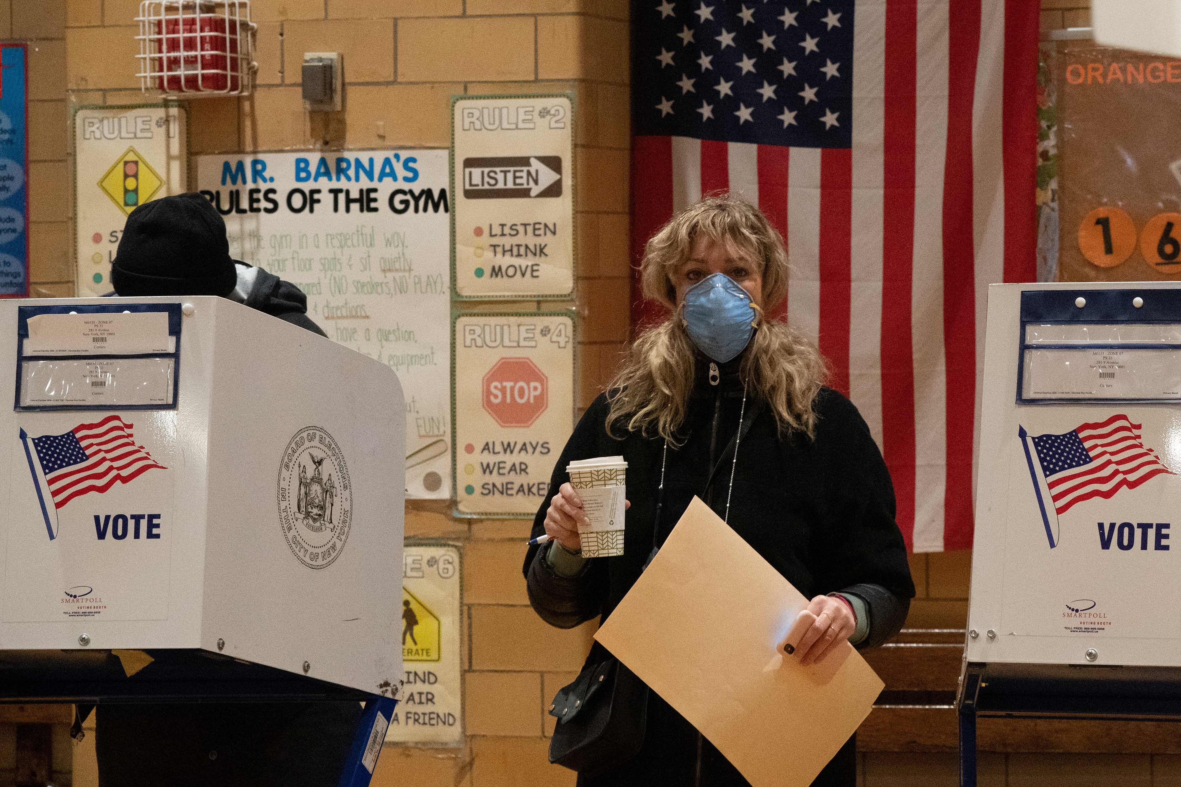 A woman carries her ballot as people vote at Public School 33 in Chelsea. Credits: AFP Photo