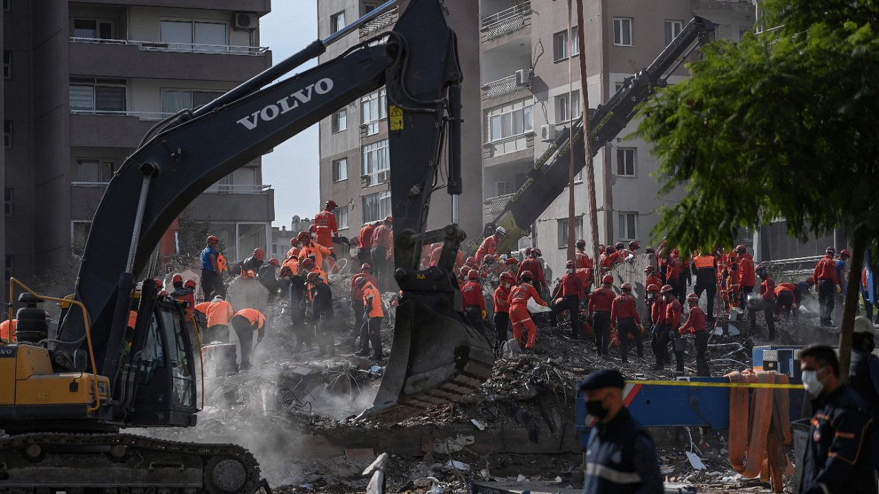 Rescue personnel use mechanical excavators as they search through the rubble of buildings at Bayrakli district in Izmir. Credits: AFP Photo