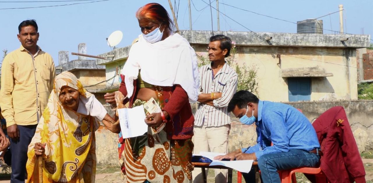 Elderly women arrive at a polling station to cast their votes for the Madhya Pradesh Assembly bypolls. Credit: PTI Photo