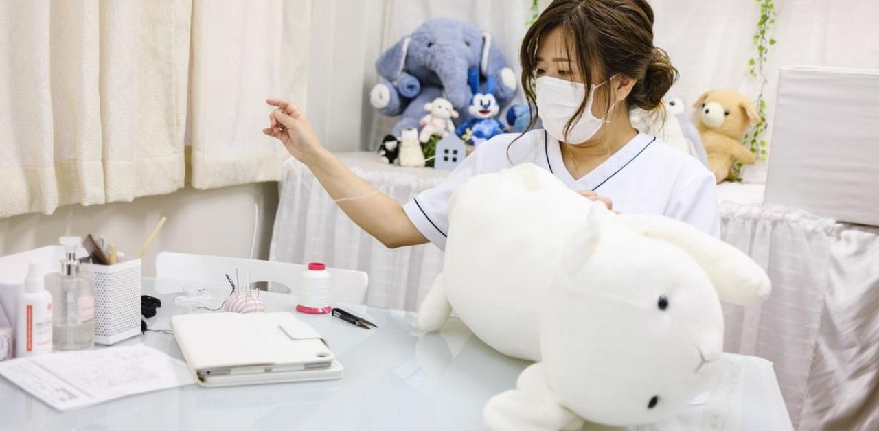 Natsumi Hakozaki working on client Yui Kato's stuffed toy sheep. Credit: AFP Photo