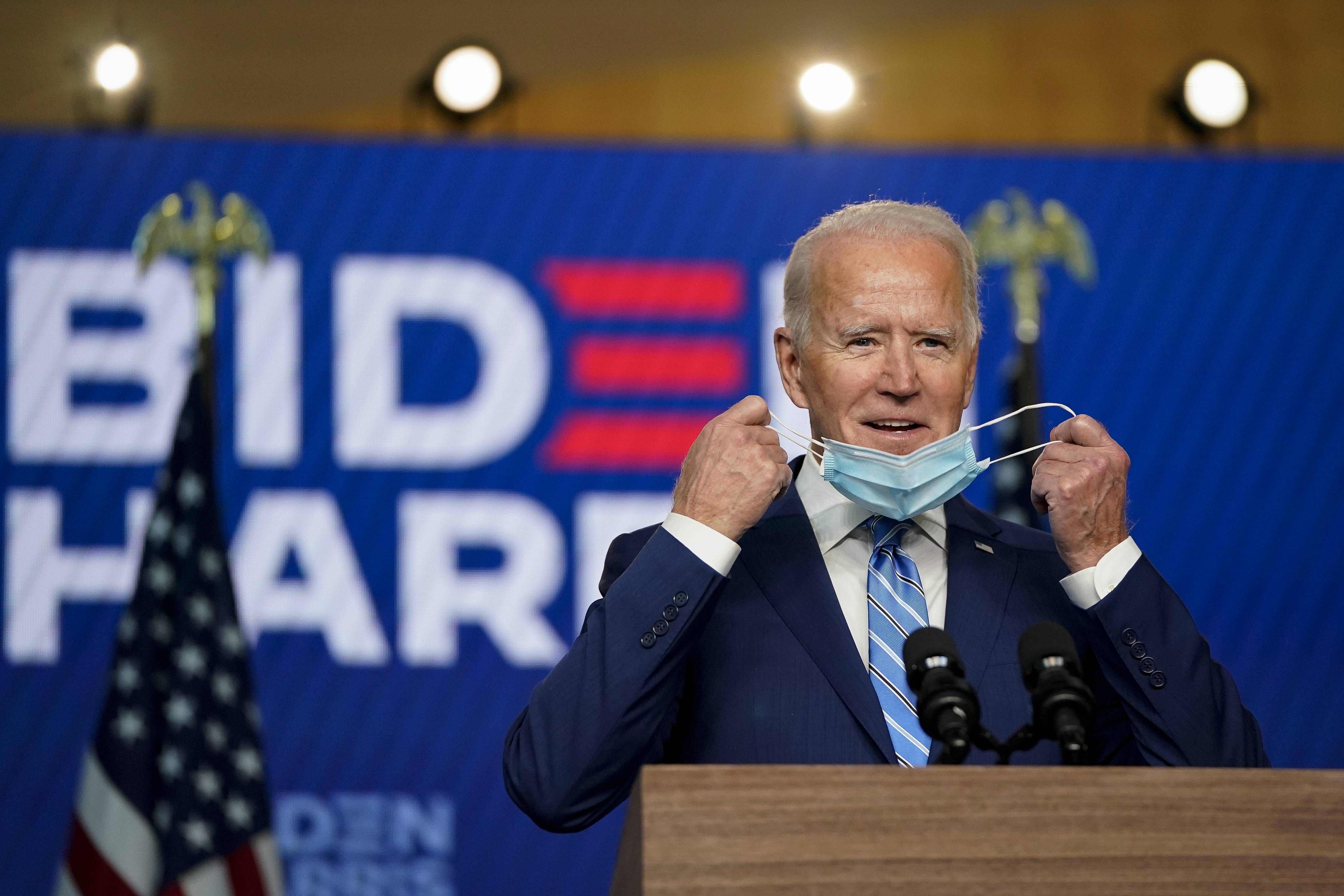 Democratic presidential nominee Joe Biden takes his face mask off as he arrives to speak one day after Americans voted in the presidential election, on November 04, 2020 in Wilmington, Delaware. Biden spoke as votes are still being counted in his tight race against incumbent U.S. President Donald Trump which remains too close to call. Credit: Getty Images/AFP