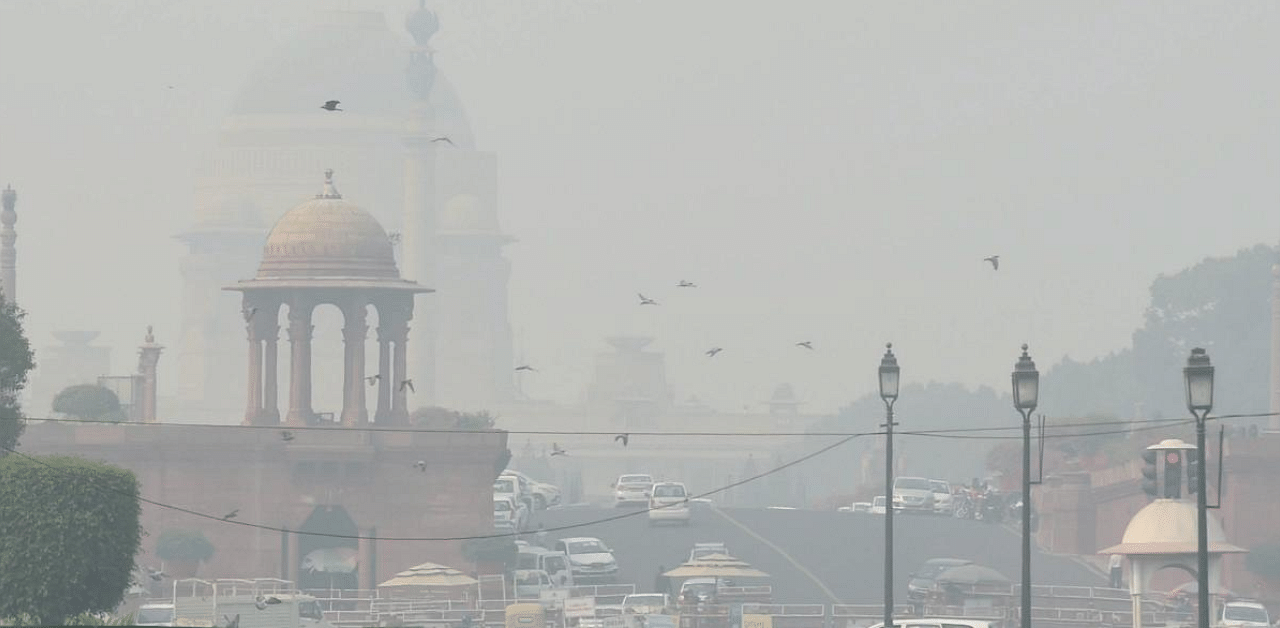 Vehicles ply at Rajpath amid low visibility due to smog, in New Delhi. Credit: PTI