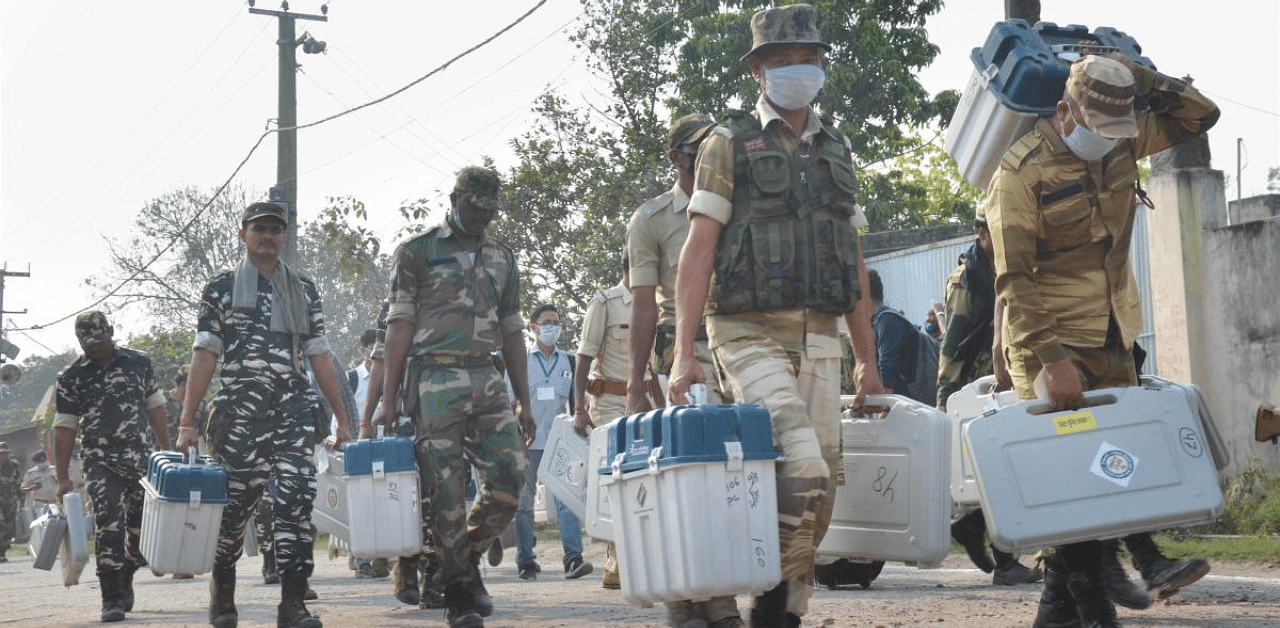 Security personnel carry Electronic Voting Machines (EVMs) as they leave for their election duty, ahead of the third and last leg of Bihar Assembly polls, in Muzaffarpur district. Credit: PTI Photo