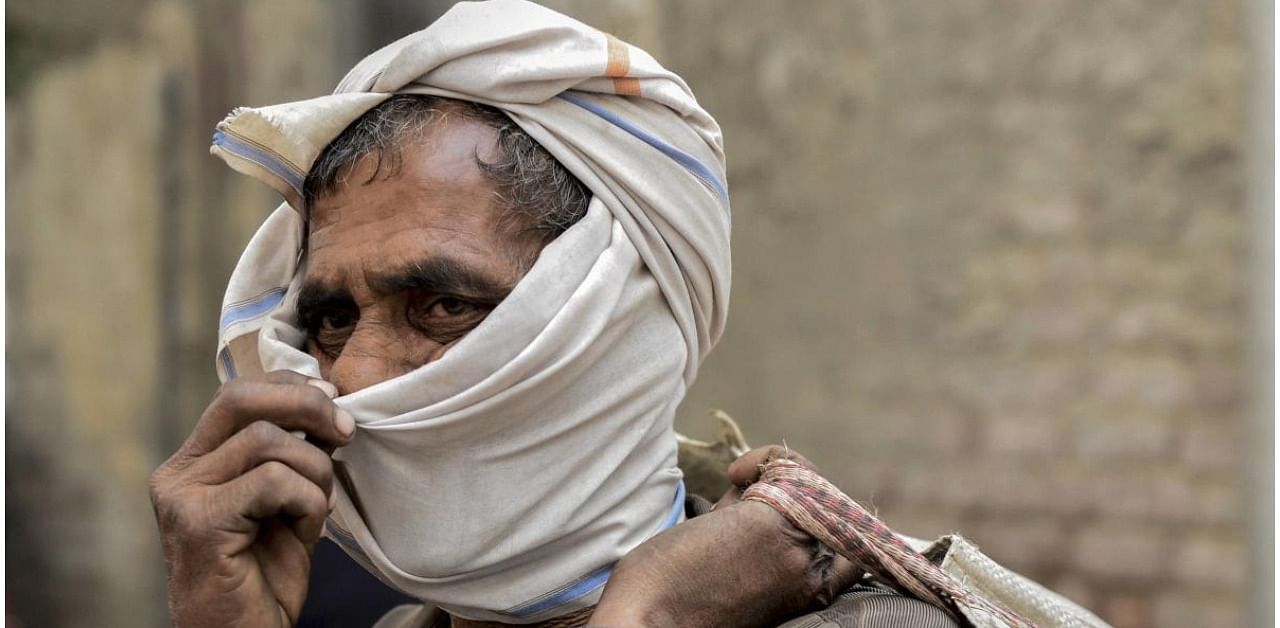 A passenger waits to undergo Covid-19 RAT test at Anand Vihar Bus Terminal, as coronavirus cases surge across the national capital, in New Delhi. Credit: PTI