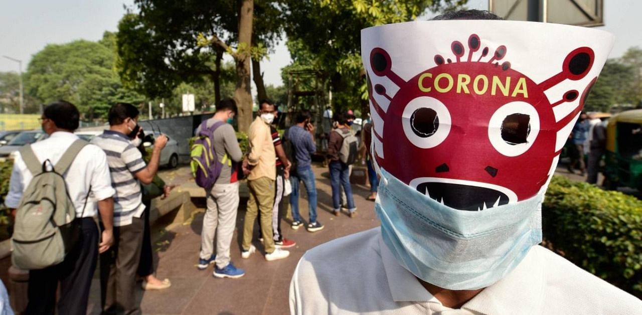 A volunteer, wearing masks, participate in a Covid-19 awareness procession as coronavirus cases rise across the national capital. Credit: PTI