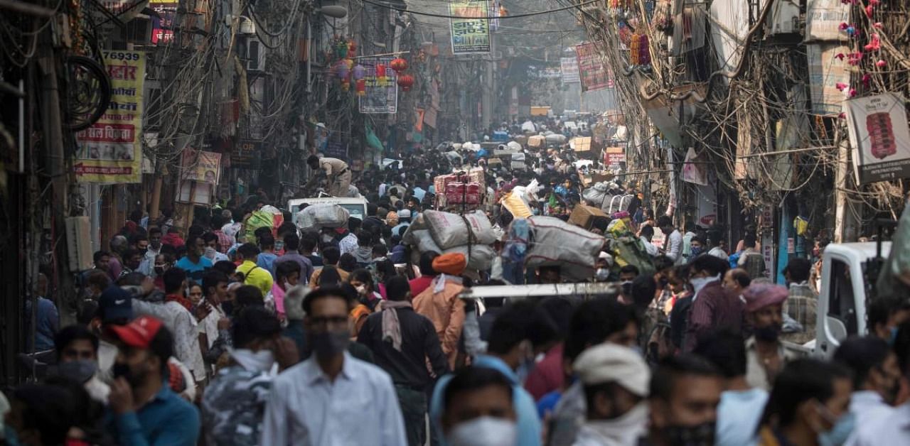 People walk along a street of a market area amid the Covid-19 pandemic in New Delhi. Credit: AFP