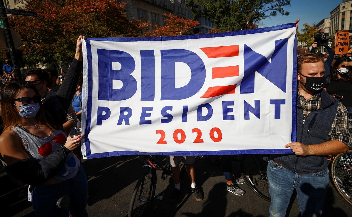 People hold a banner after media announced that Democratic U.S. presidential nominee Joe Biden has won the 2020 U.S. presidential election, on Black Lives Matter Plaza near the White House. Credit: Reuters