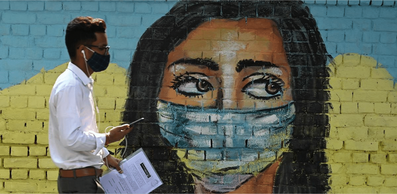 A man walks past a mural depicting the Covid-19 coronavirus in New Delhi. Credit: AFP