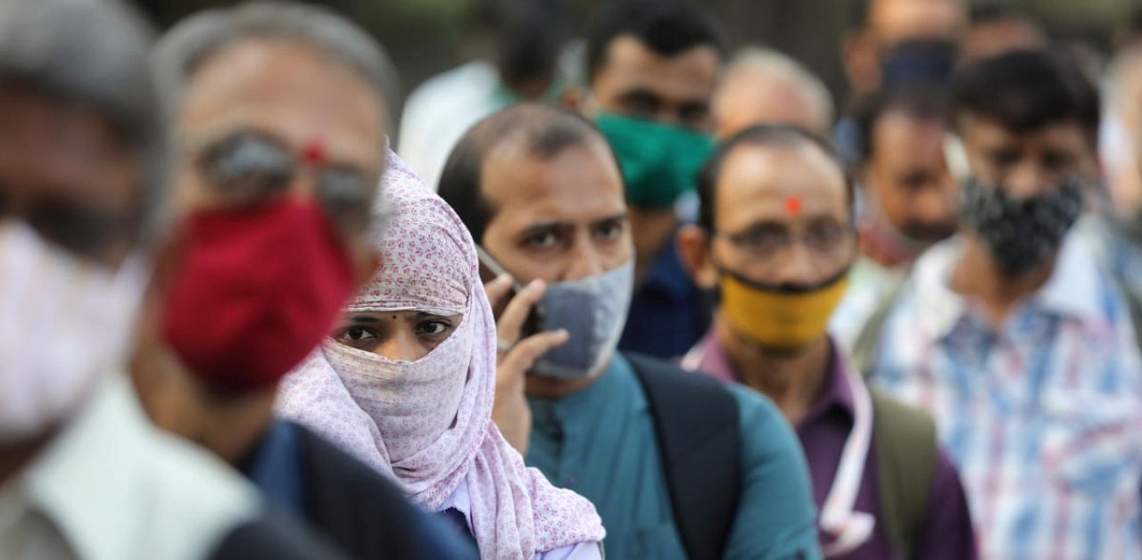 People wearing protective masks wait in line to board a bus amidst the spread of the coronavirus disease (COVID-19) in Mumbai, India, October, 6, 2020. Credit: Reuters Photo
