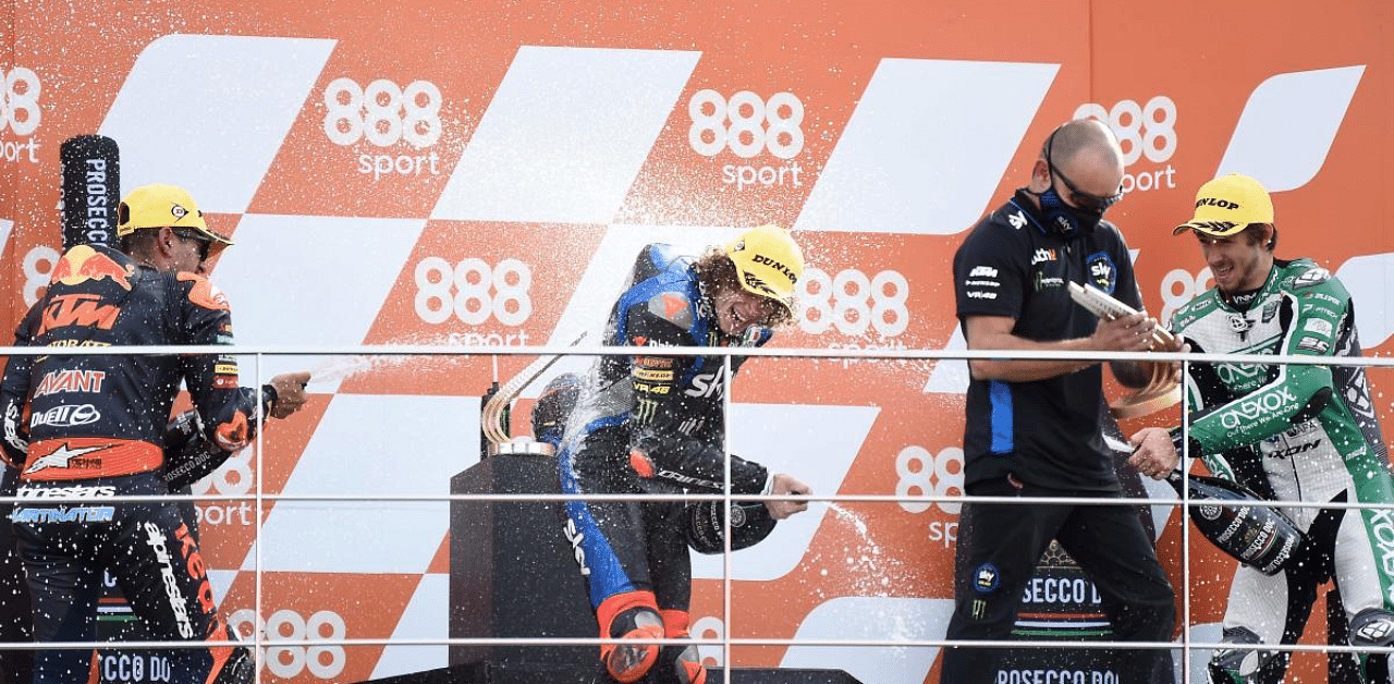 Race winner SKY Racing Team VR46's Italian rider Marco Bezzecchi (C) celebrates on the podium. Credit: AFP Photo