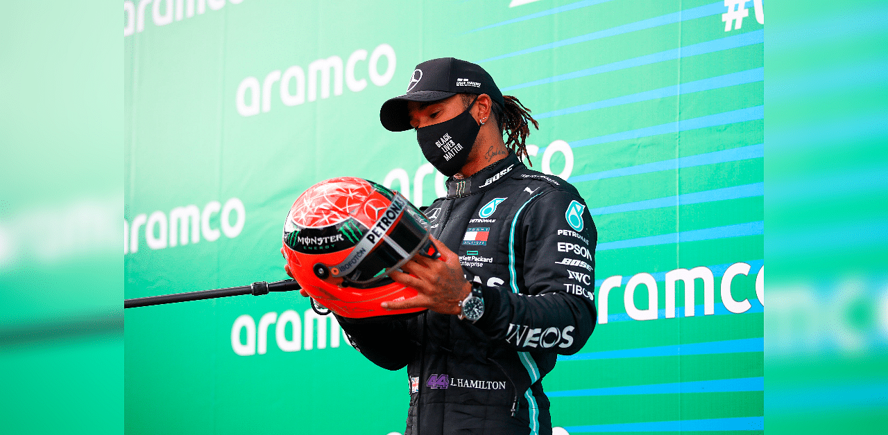 Mercedes driver Lewis Hamilton with one of Michael Schumacher's helmets, which was presented to him by Mick Schumacher. Credit: AFP Photo