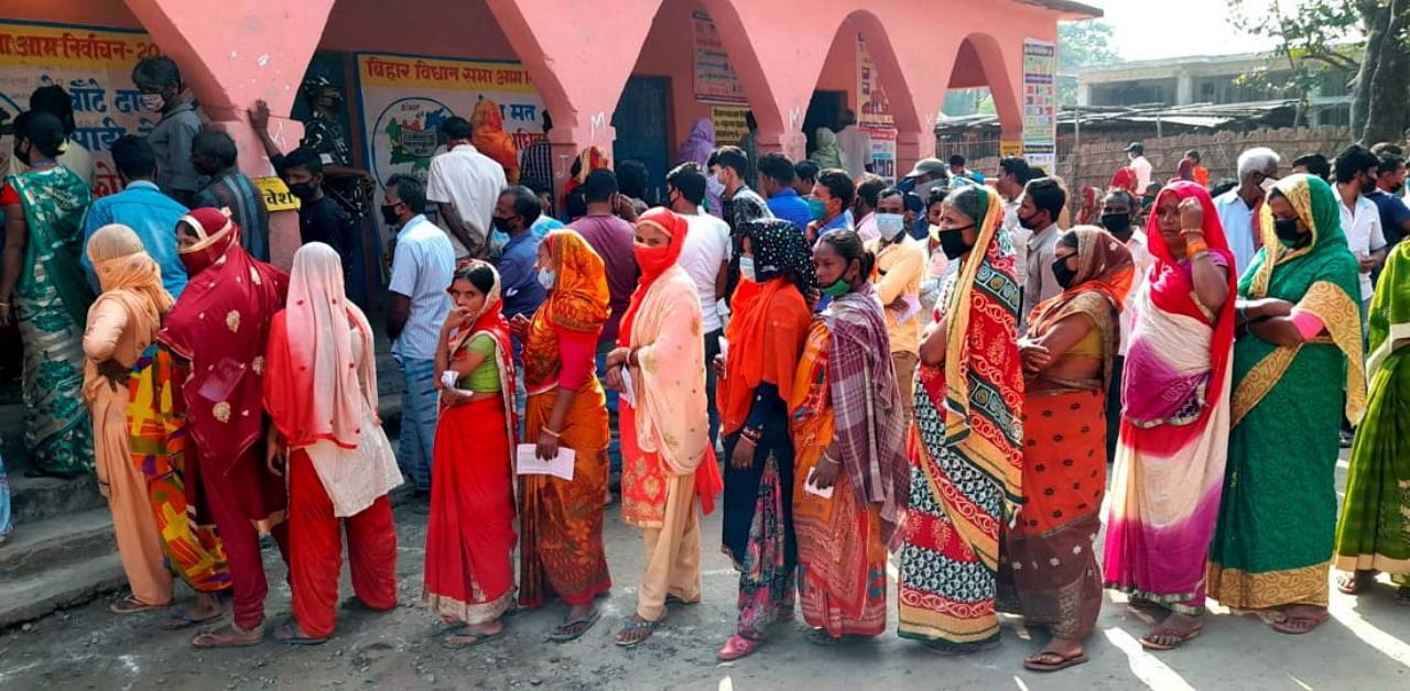 People wait in queues at a polling station to cast votes for the third phase of Bihar Assembly elections, in Kishanganj. Credit: PTI.