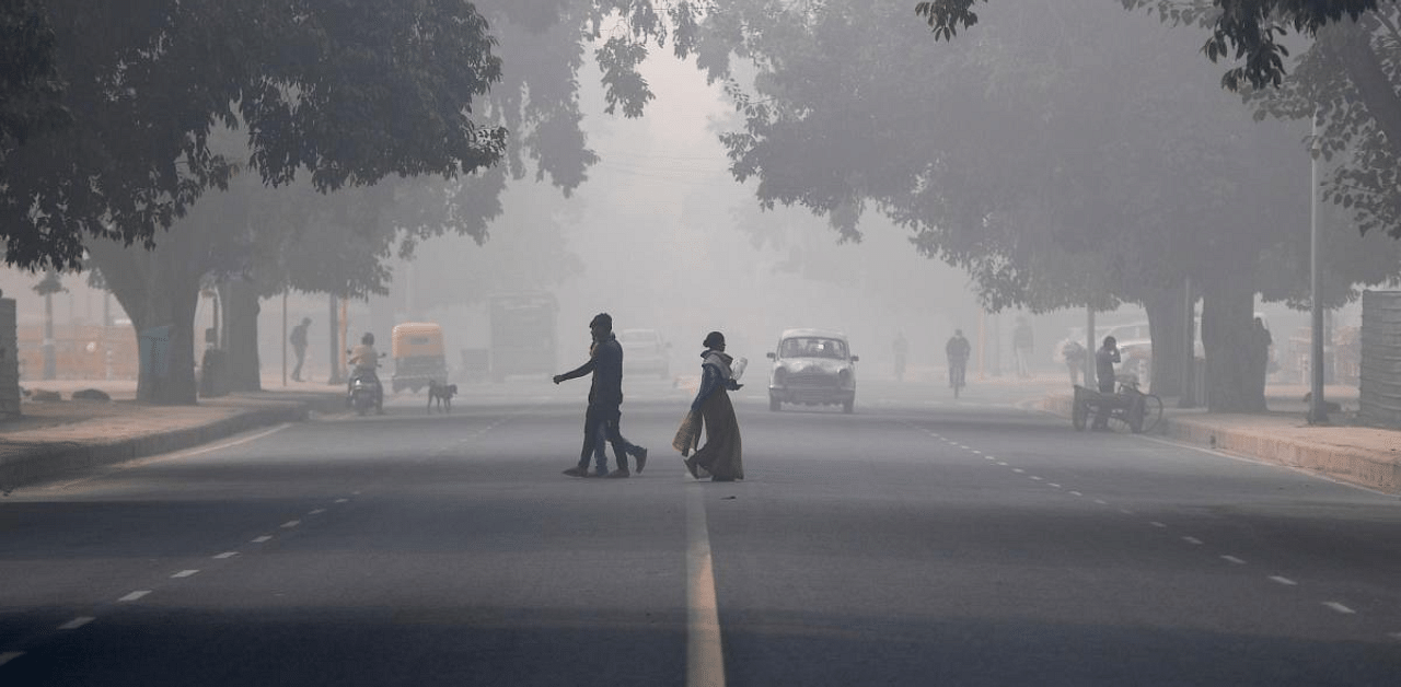 People cross a road amid heavy smoggy conditions in New Delhi on November 10. Credit: AFP Photo