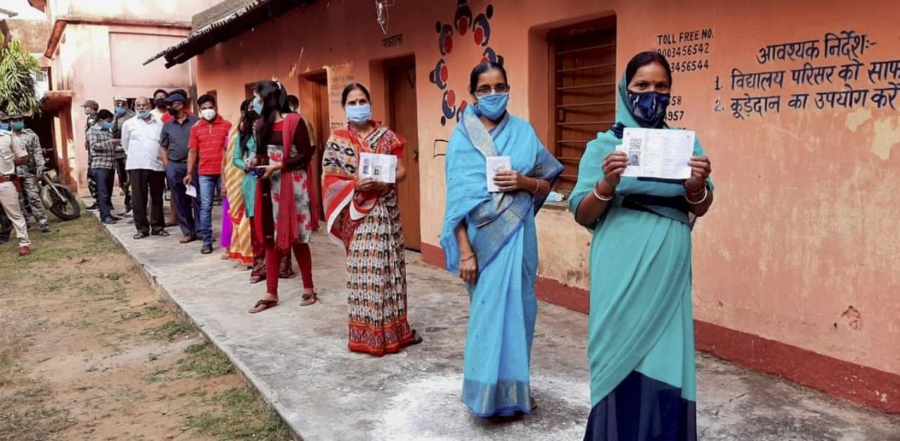 Women show their fingers marked with indelible ink after casting vote during the Jharkhand Assembly bypolls, amid the ongoing coronavirus pandemic. Credit: PTI