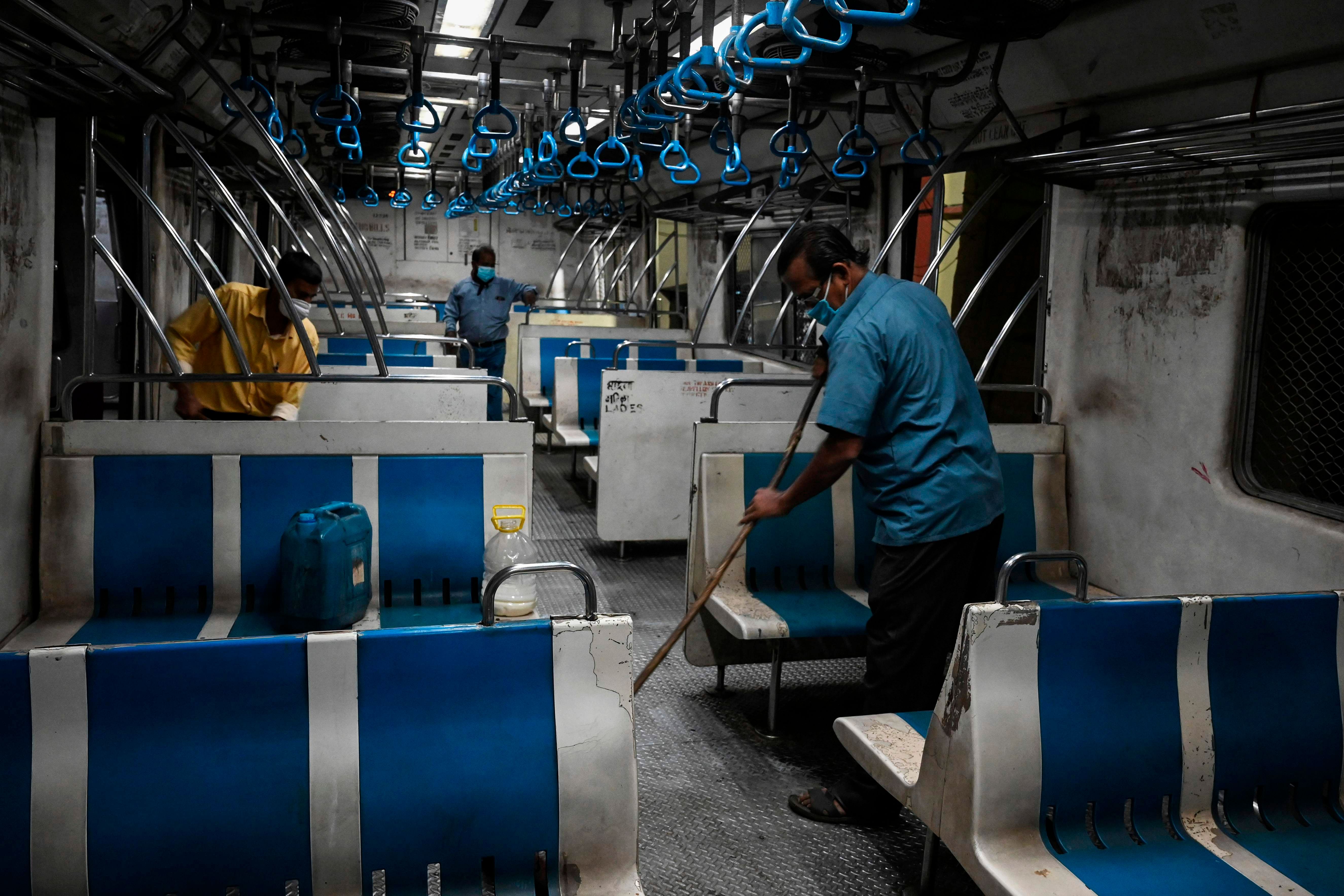 Indian Railways contract staff clean a train carriage at a train shed in Kolkata. Credits: AFP Photo