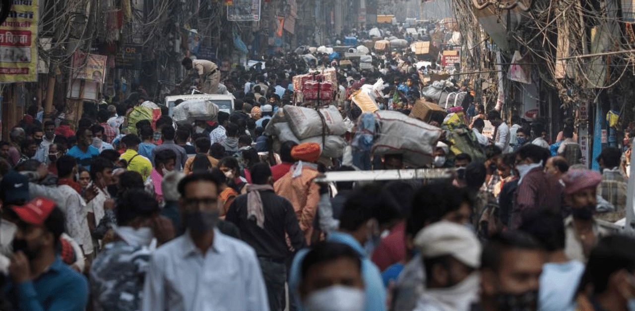 People walk along a street of a market area amid the Covid-19 coronavirus pandemic in New Delhi on November 7, 2020. Credit: AFP Photo