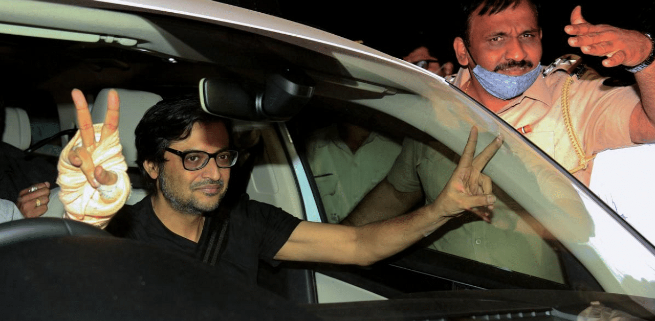 Arnab Goswami flashes a victory sign from inside his car after his release from prison on interim bail. Credit: AFP Photo