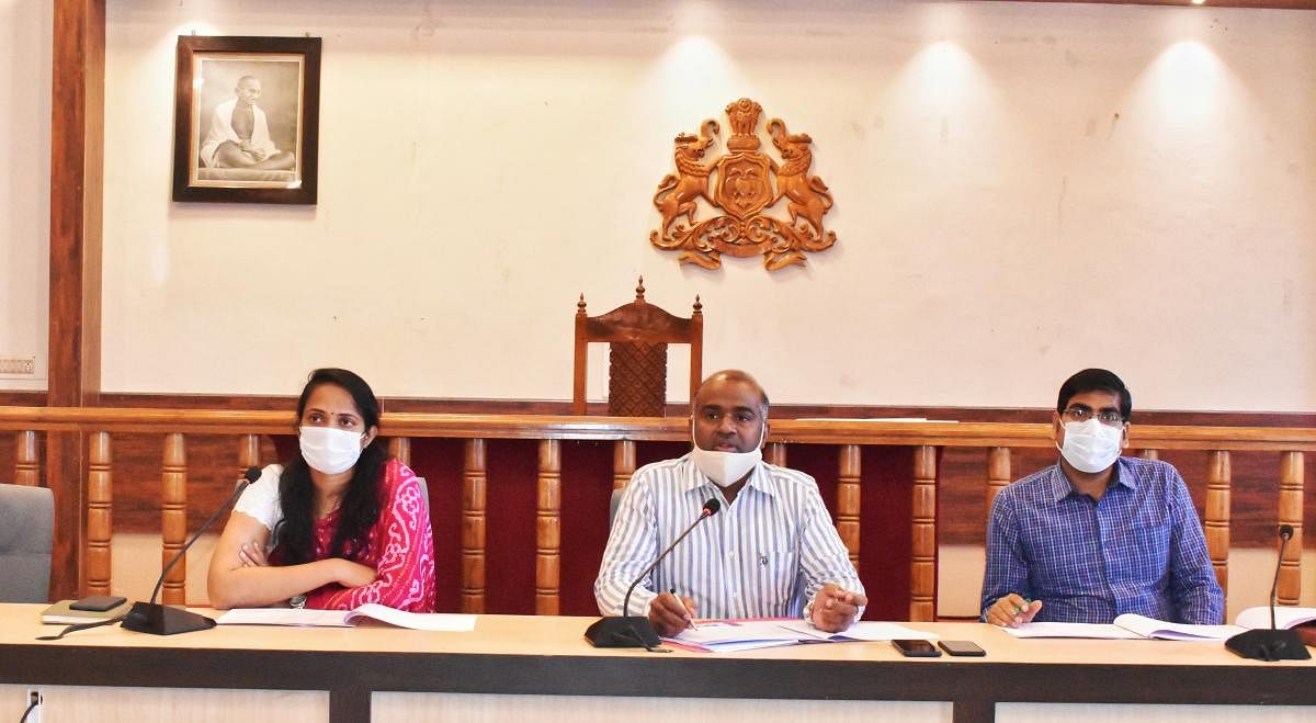 District In-charge Secretary V Anbu Kumar speaks at a meeting in Madikeri.