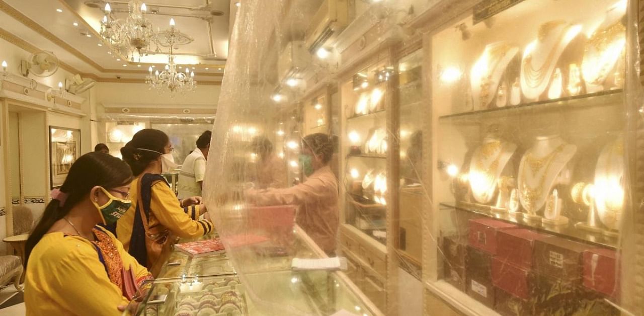People buy gold ornaments at a jewellery showroom on the auspicious occasion of Dhanteras, in Kolkata. Credit: PTI