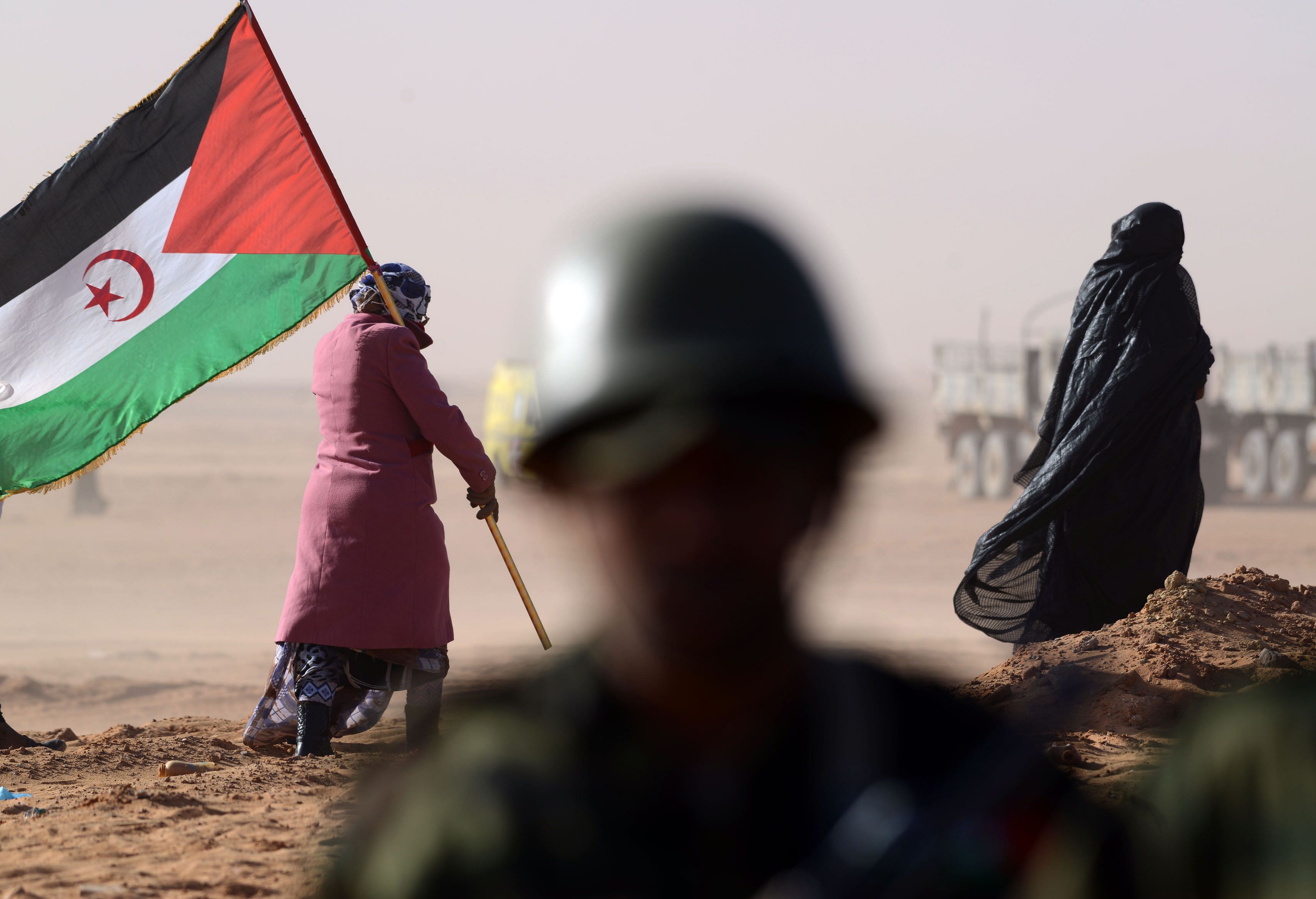 A Sahrawi woman holds a Polisario Front's flag during a ceremony to mark 40 years after the Front proclaimed the Sahrawi Arab Democratic Republic (SADR) in the disputed territory of Western Sahara. - Morocco announced on November 13, 2020 that its troops have launched an operation in no man's land on the southern border of the Western Sahara to end "provocations" by the pro-independence Polisario Front. Credit: AFP Photo