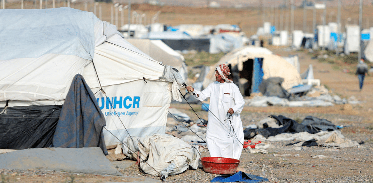 A displaced Iraqi man dismantles his tent as he prepares to be evacuated, at Hammam Al-Alil camp, south of Mosul. Credit: Reuters Photo