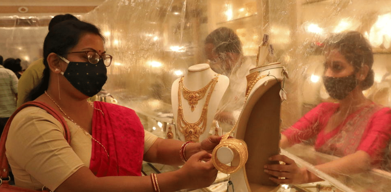 Woman looks at a gold necklace at a jewellery showroom during Dhanteras, a Hindu festival associated with Lakshmi, the goddess of wealth, amidst the spread of COVID-19 in Kolkata, India, November 13, 2020. Credit: Reuters Photo