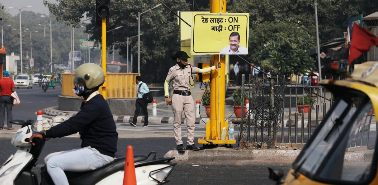 Rihana Saif holds a placard instructing motorists to turn off their engines in Delhi. Credit: Reuters Photo