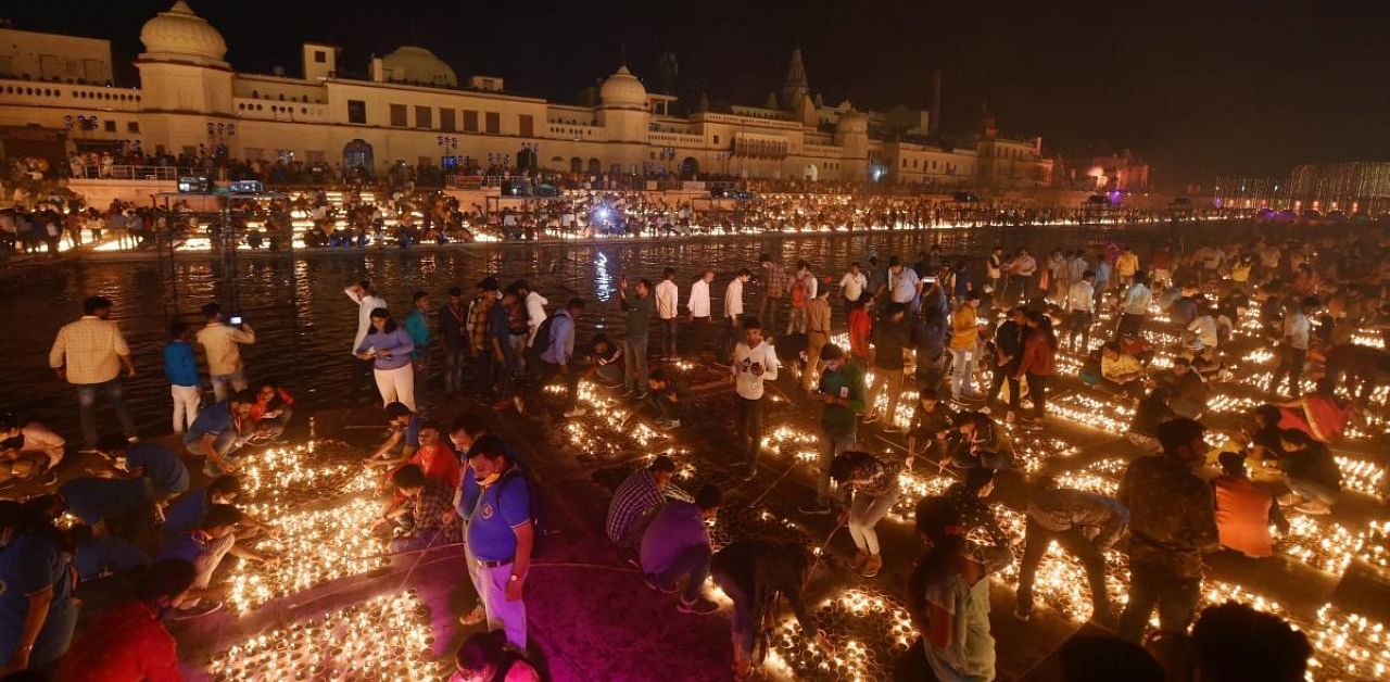 Devotees light earthen lamps on the bank of Saryu River during Deepotsav celebrations in Ayodhya. Credit: PTI